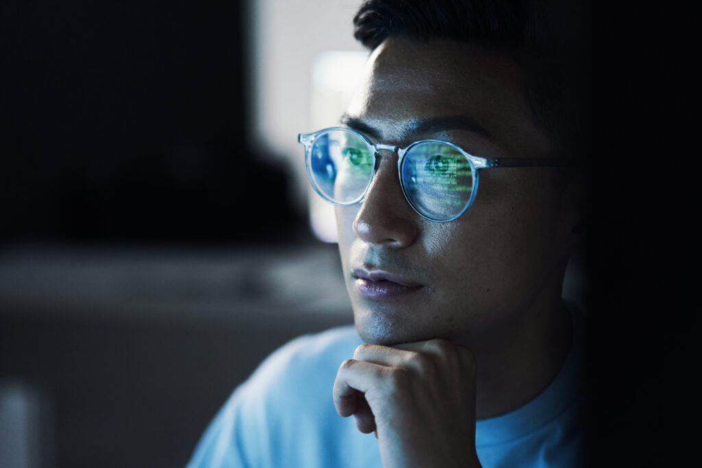 code, asian man and reflection in glasses, focus and programming for cyber security, hacking and modern office. japan, male employee with eyewear and it specialist coding, programming and thinking